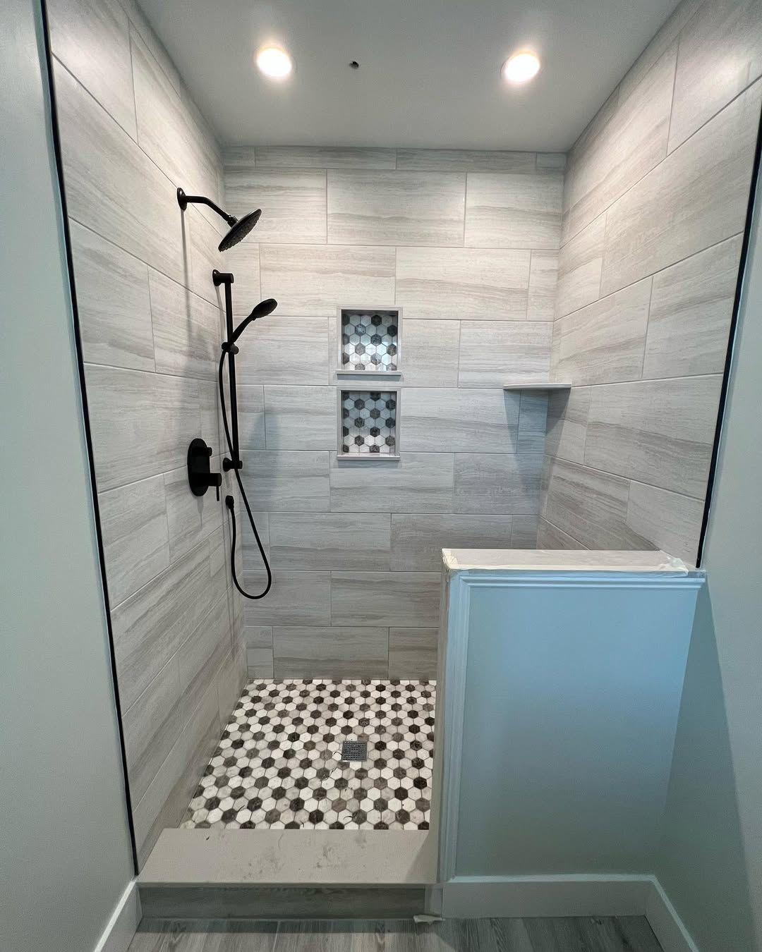 A completed shower with gray tile backsplash and hexagon floor tile