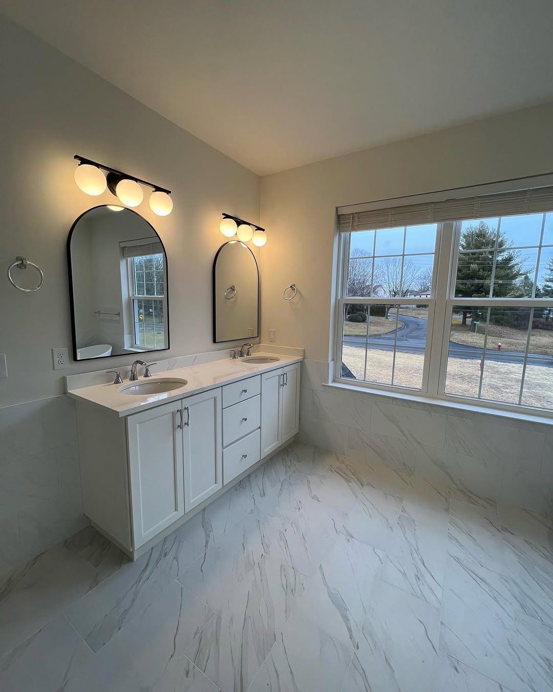 A finshed double vanity with arch mirrors.